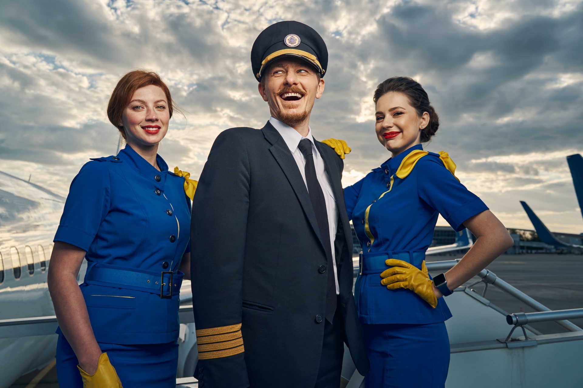 cheerful-aviator-and-flight-attendants-standing-on-the-boarding-stairs-e1630639237397.jpg